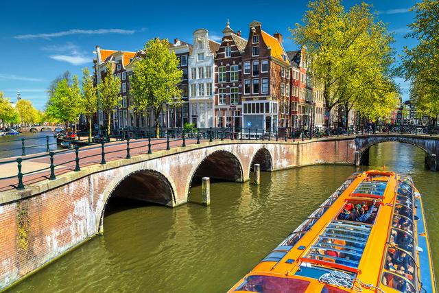 Picturesque canal in Amsterdam with bicycles and traditional architecture.