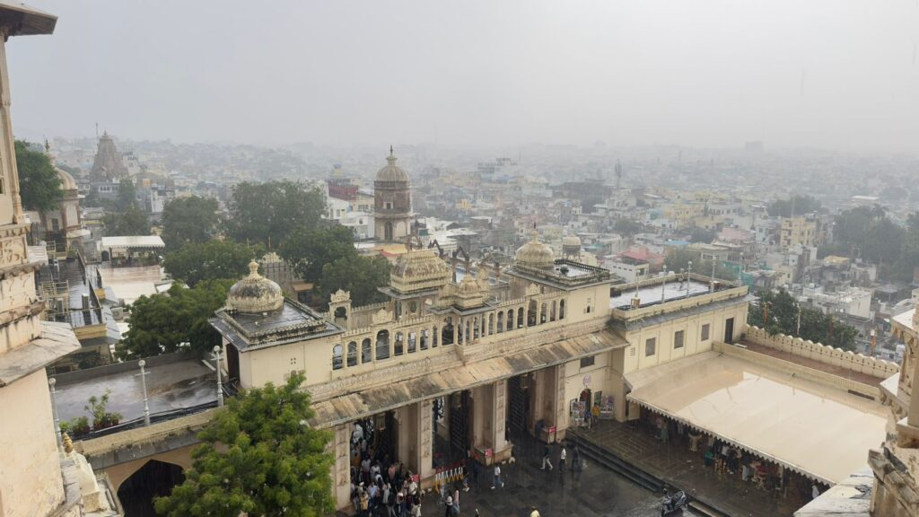 iew through an intricately carved window of Udaipur's City Palace, overlooking the city and Lake Pichola