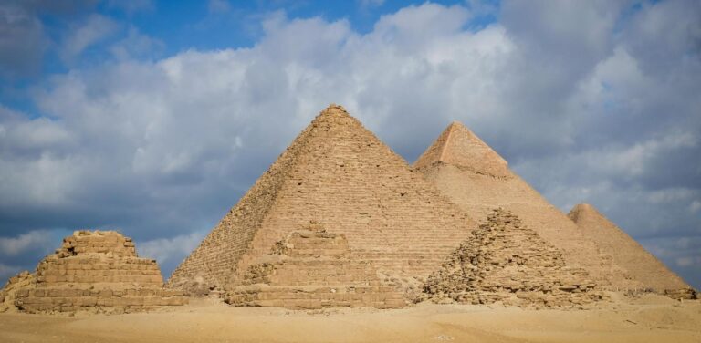 The Great Pyramids of Giza and the Sphinx under a clear blue sky in Cairo, Egypt.