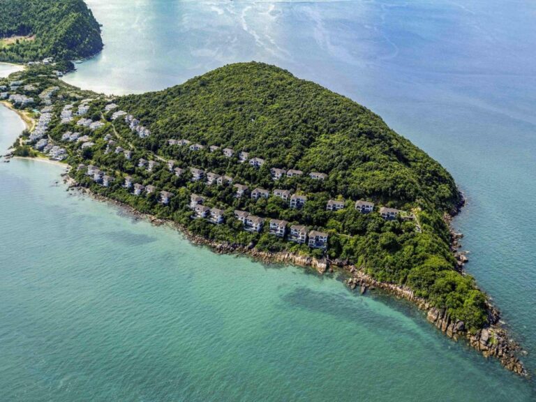 Aerial view of Premier Village Phu Quoc Resort Managed by Accor – lush green hillside villas with private pools on a secluded peninsula, surrounded by turquoise sea and beaches, Phu Quoc Island Vietnam