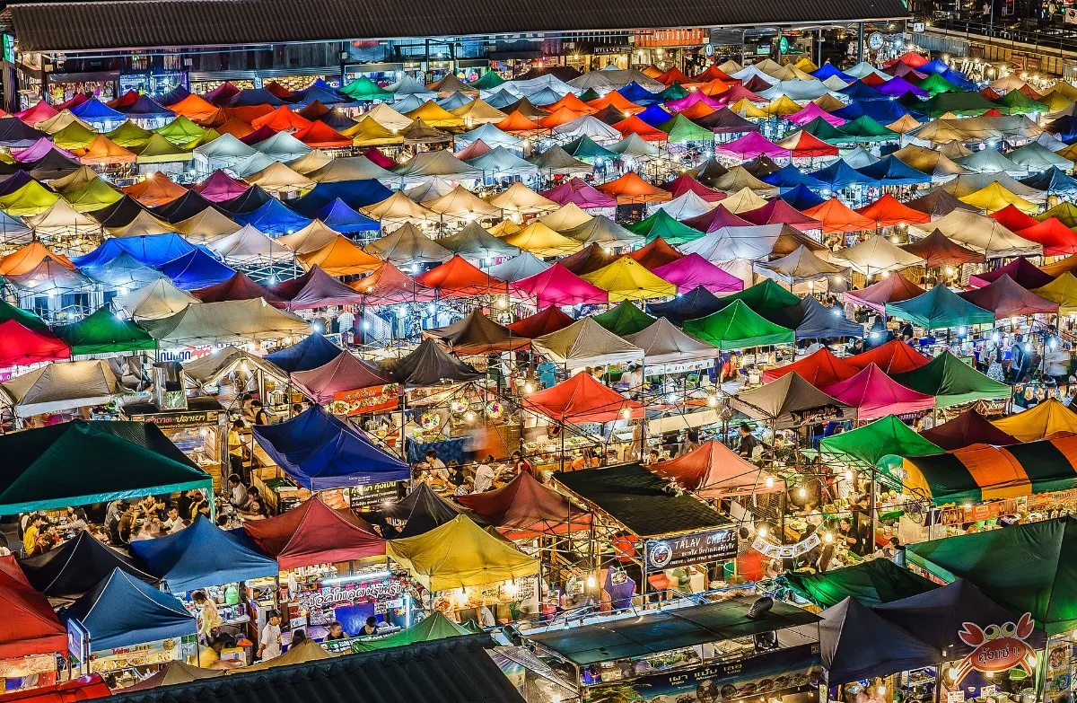 Colourful rows of tented stalls at Train Night Market Ratchada in Bangkok, seen from above at night