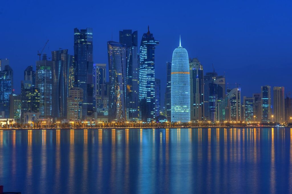 Doha West Bay skyline at night — Qatar Airways' hub for India–US connections