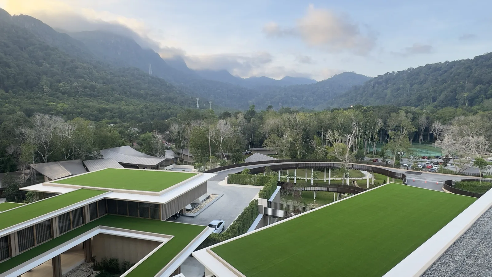 Green rooftops of Hilton Burau Bay Langkawi with rainforest mountains and SkyCab cable car towers behind