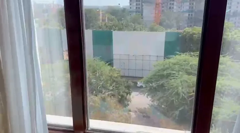 View from a Royal Premier Room window at The Leela Palace New Delhi showing a construction site behind trees