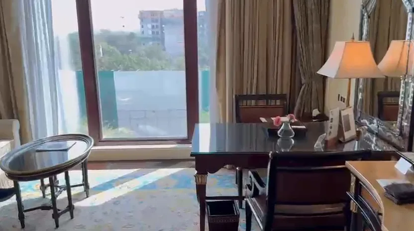 Royal Premier Room at The Leela Palace New Delhi with a writing desk, armchair and large windows