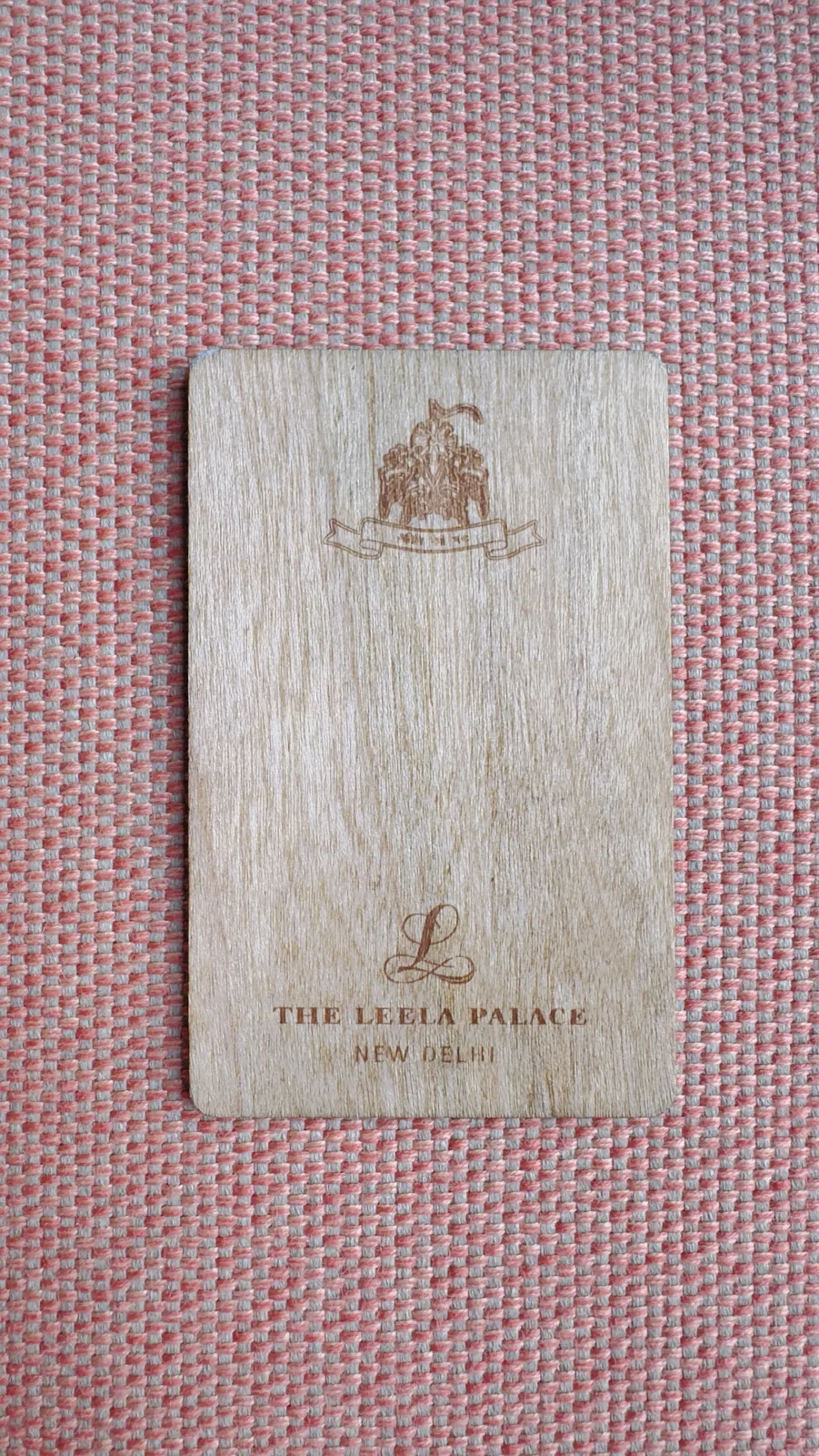 Wooden room key card engraved with The Leela Palace New Delhi logo